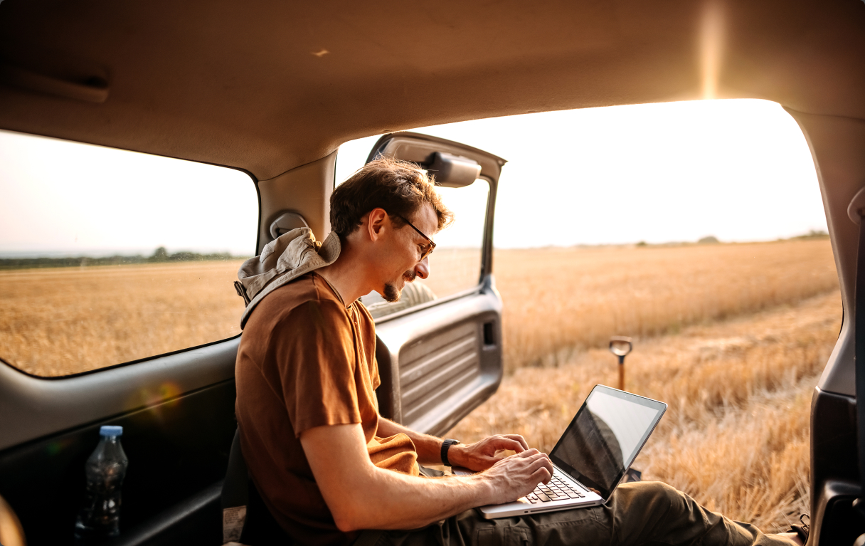 Research (1) guy looking at laptop in field