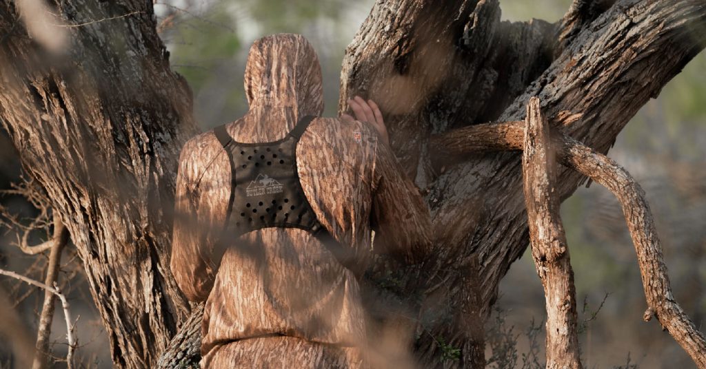 camo, looking through tree