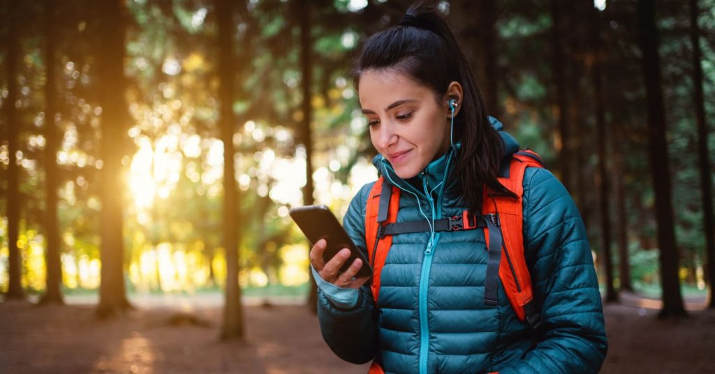 Girl looking at phone on hike