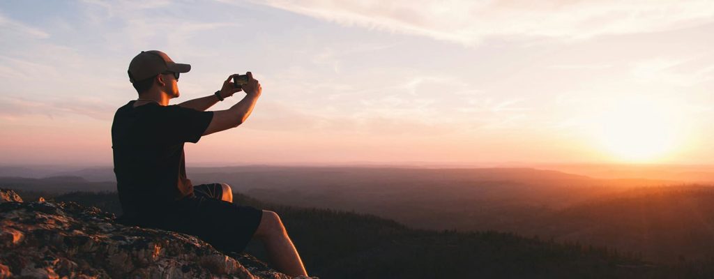 guy taking picture of sunset